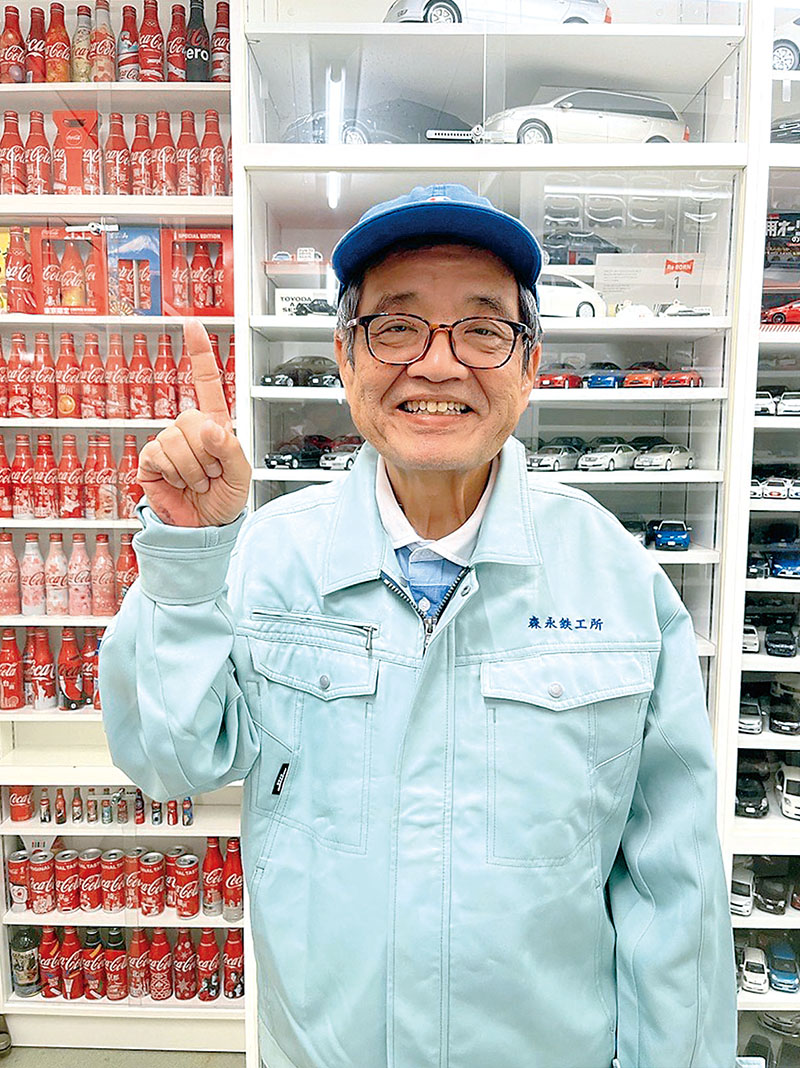 自身のコレクションを前に笑顔を見せる森永卓郎さん（2022年5月撮影、同館提供）