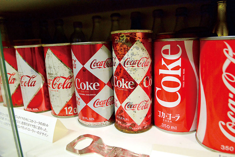 初期の「ダイヤ缶」や「ボトルダイヤ缶」をはじめ歴代コカ・コーラの空き缶がそろう