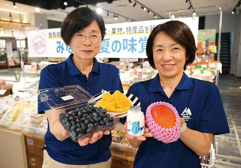 「みなかみ夏の味覚展」で販売されるブルーベリーやヨーグルトをPRするみなかみ町職員