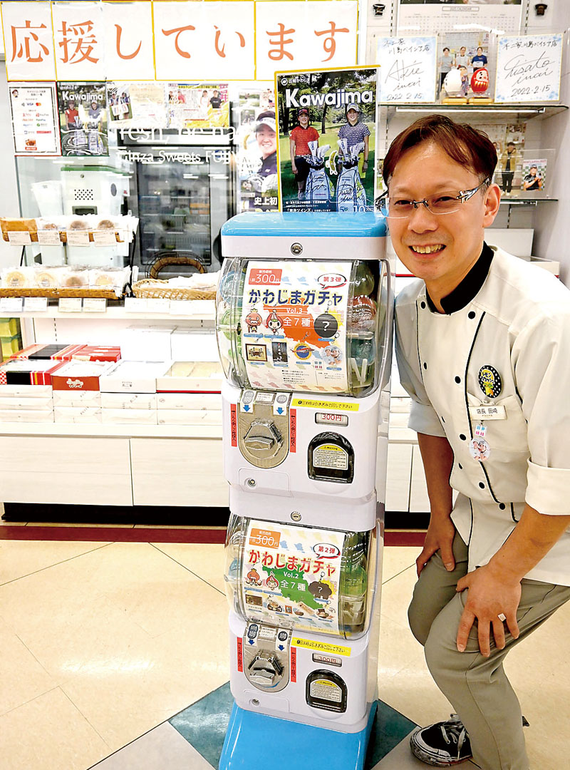 岩井姉妹コーナーの前に設置された「かわじまガチャ」と、オーナーの田崎徹也さん＝22日、川島町上伊草の不二家川島ベイシア店