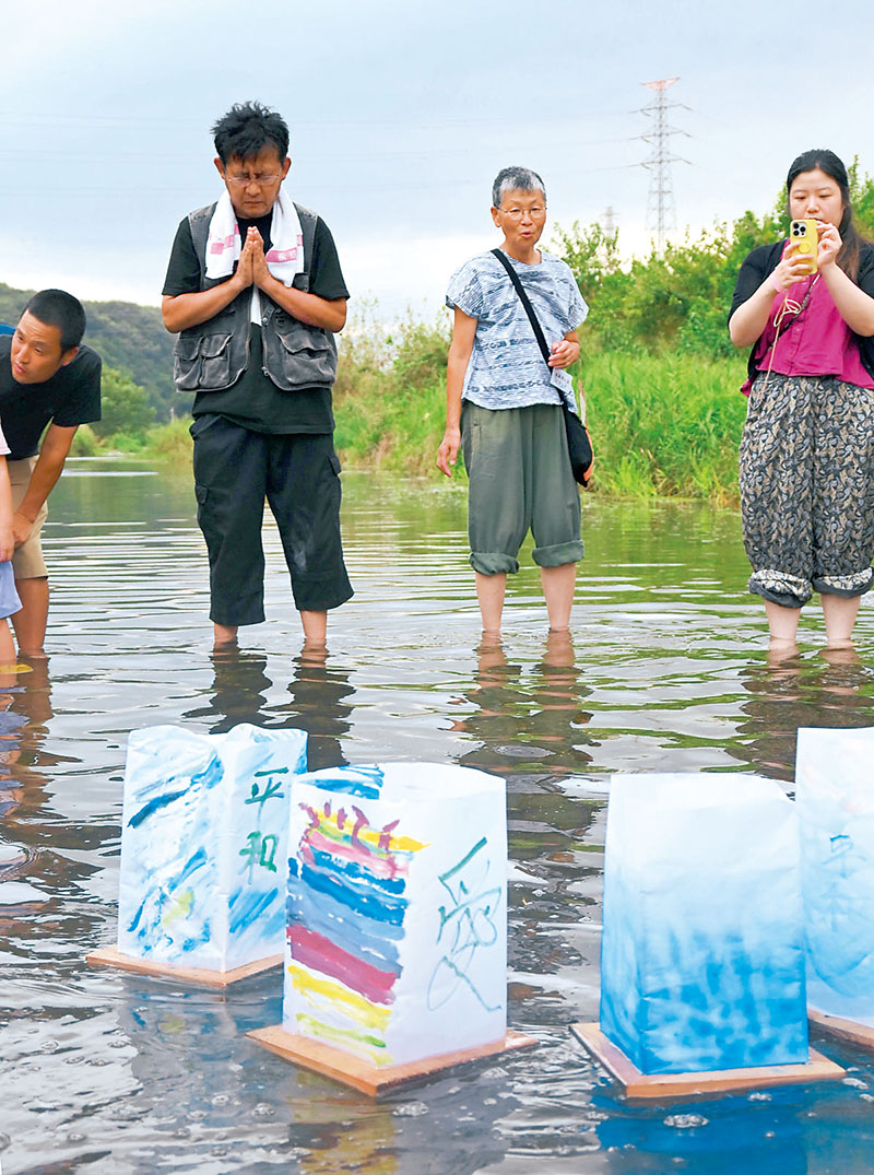 原爆犠牲者を悼み、平和への祈りをささげて灯籠を流す参加者ら＝6日午後5時半ごろ、東松山市下唐子の都幾川