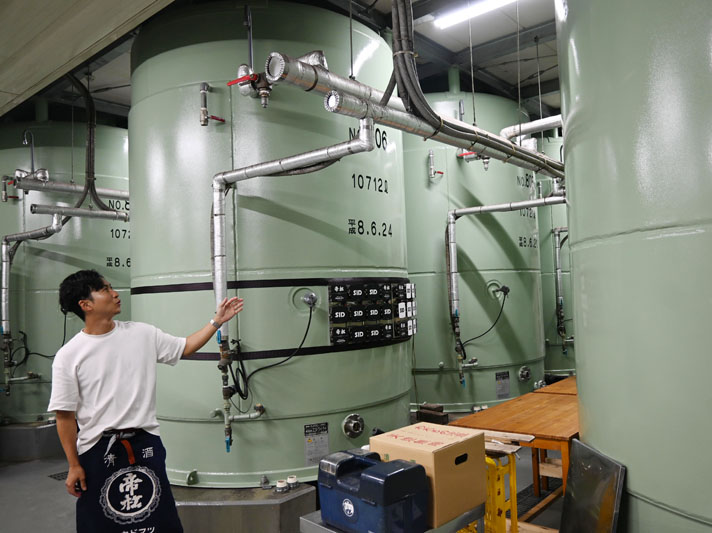 低温で発酵させるタンクと社長の松岡奨さん＝小川町下古寺