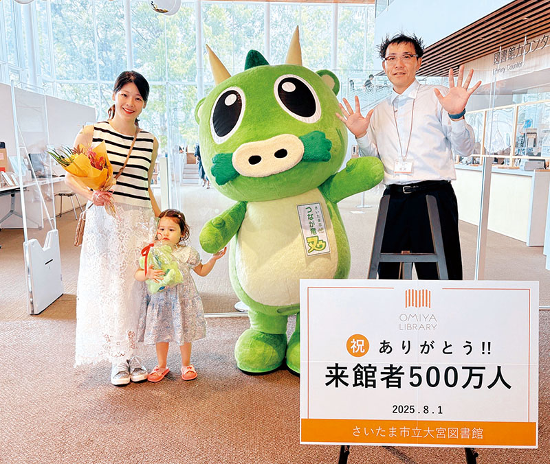 500万人目の来館者となった親子に馬渕忠秀館長（右）から記念品が贈呈された