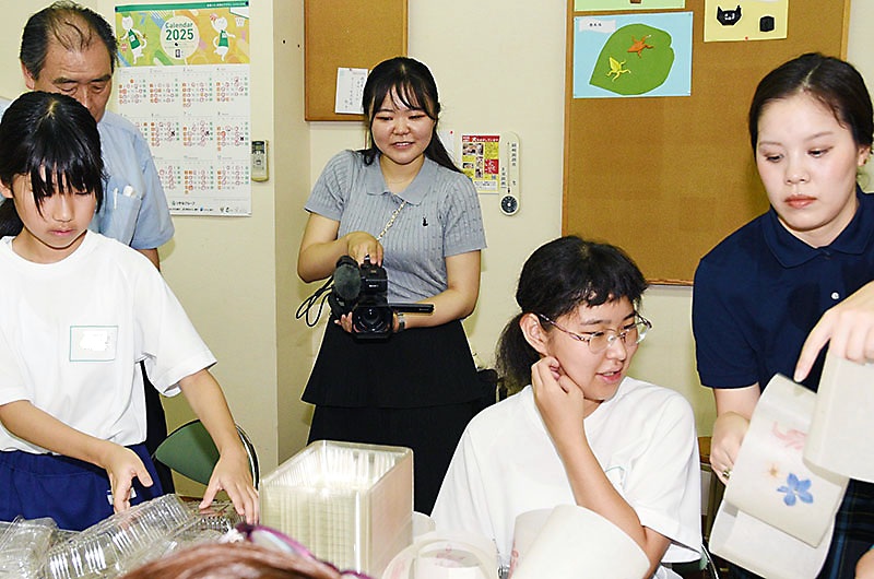 「星川とうろう流し」に向けた灯籠作りを撮影する松田みなみさん（中央）  ※画像の一部を加工しています