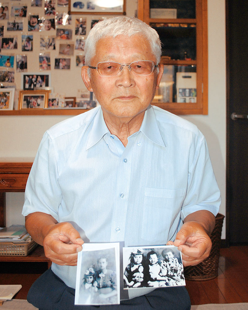 母親の清子さんが大切に保管していた樺太時代の写真を見せながら清子さんから聞いた体験を話す山口靖史さん＝上尾市