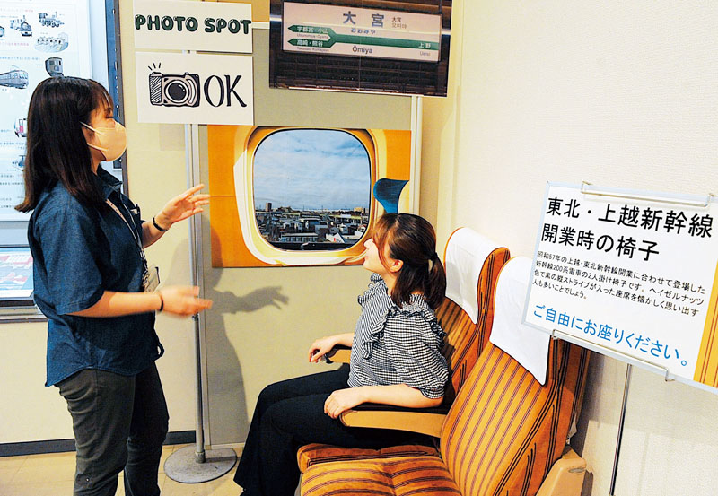 東北・上越新幹線の開業時の椅子について、博物館実習生に解説する瀧本美佳学芸員（左）＝15日、さいたま市大宮区の市立博物館