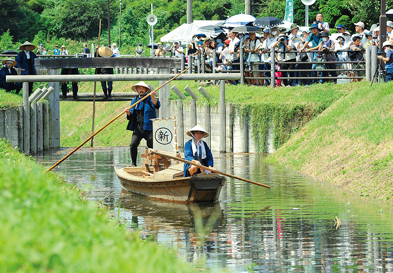 実物の2分の1に復元された船が水位の上がった水路を往復する＝20日午前、さいたま市緑区