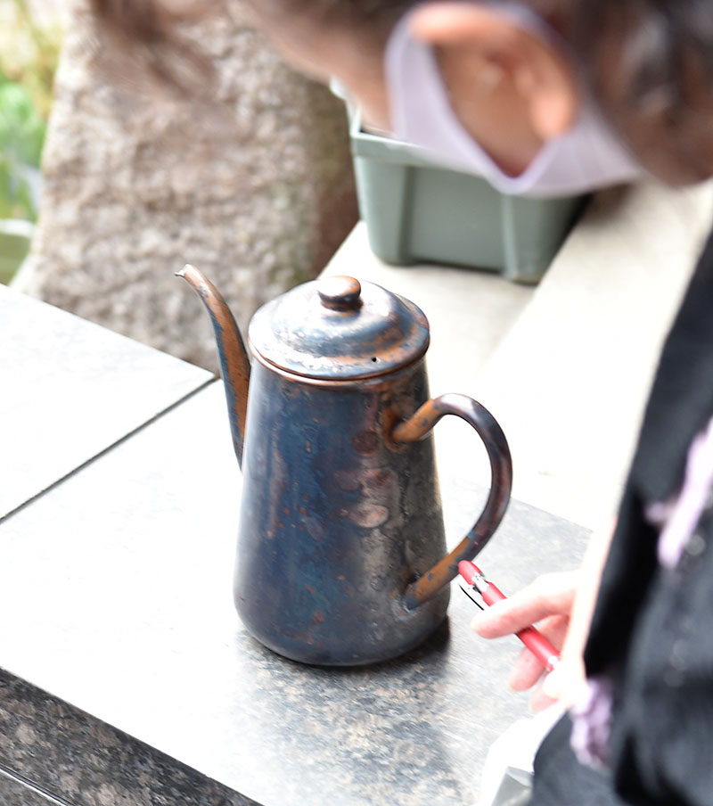 女性が補償説明会に持参した銅製のポット