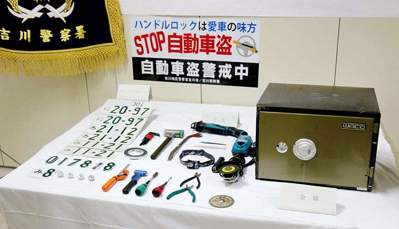 犯行時に使用したとみられる工具やナンバープレートと被害品の金庫＝21日午前、吉川署