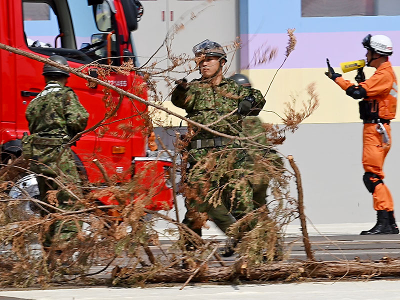 道路に散らばる障害物を取り除く自衛隊員ら