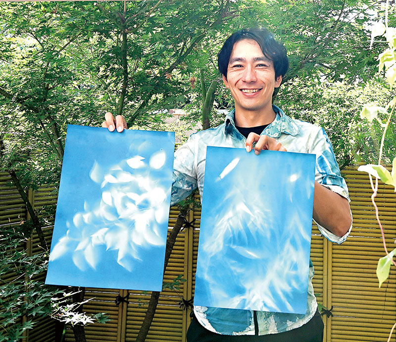 戦後80年の節目の夏に撮影した広島の被爆樹木シダレヤナギ（右）と長崎の被爆クスノキのフォトグラムを手にする浅見俊哉さん＝8月14日、さいたま市南区「コトコト」