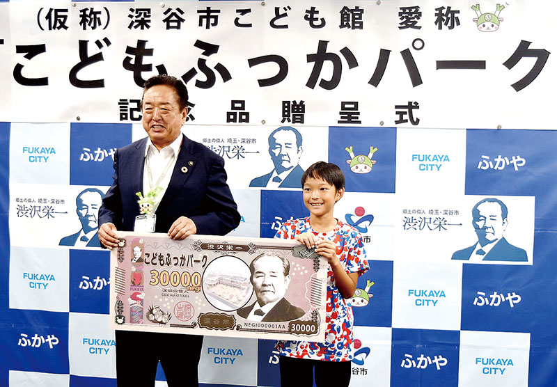 小島進市長（左）から記念品を受け取る福島敬仁さん