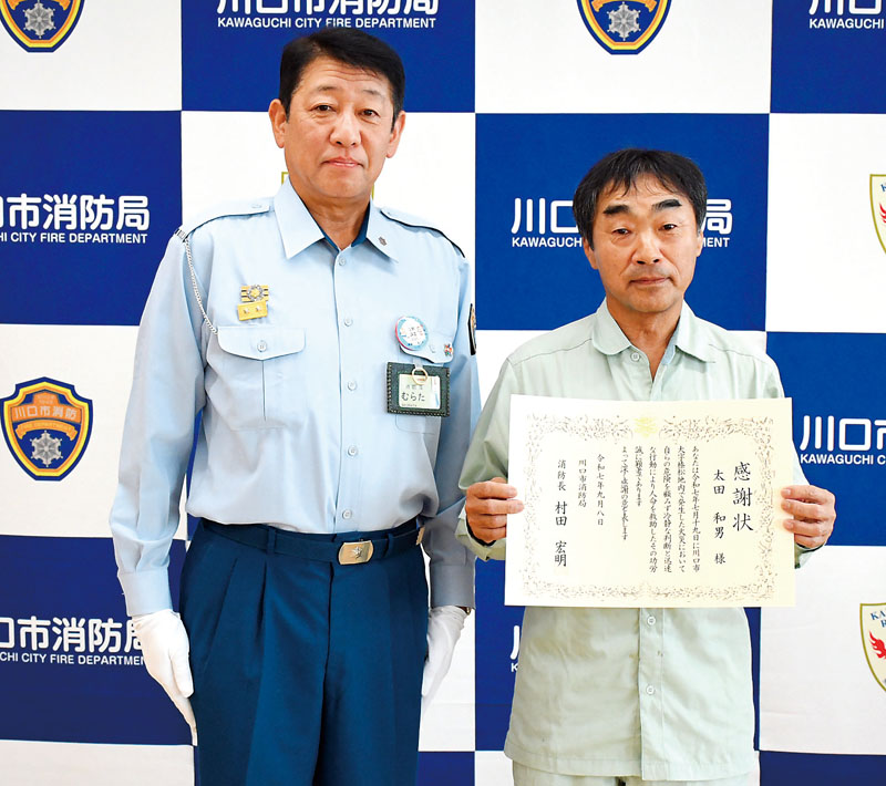 村田宏明市消防長から感謝状を受けた太田和男さん（右）＝8日午後、川口市消防局東消防署