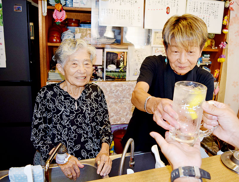 カウンターで接客する岩崎房子さん（左）と次女の由美さん