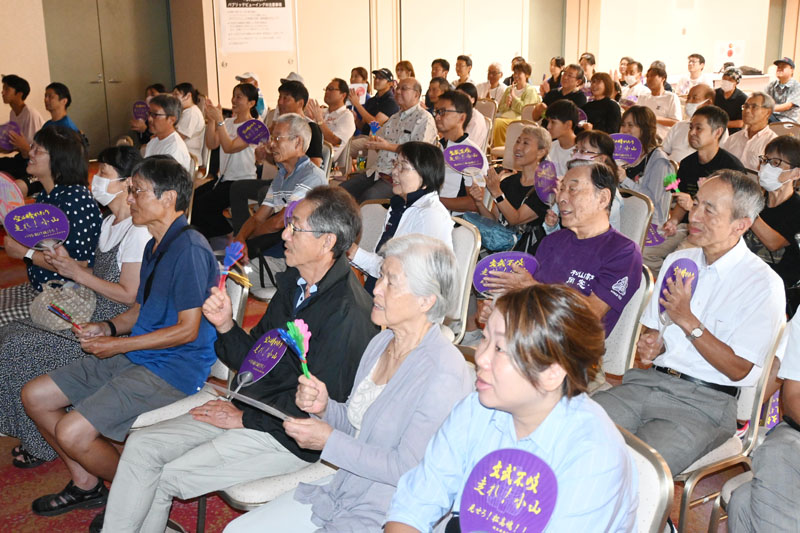 応援うちわを手に世界陸上男子マラソンのテレビ中継を見守る市民ら