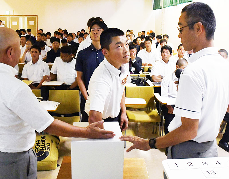 真剣な表情でくじを引く各校の主将ら＝19日午後、スポーツ総合センター
