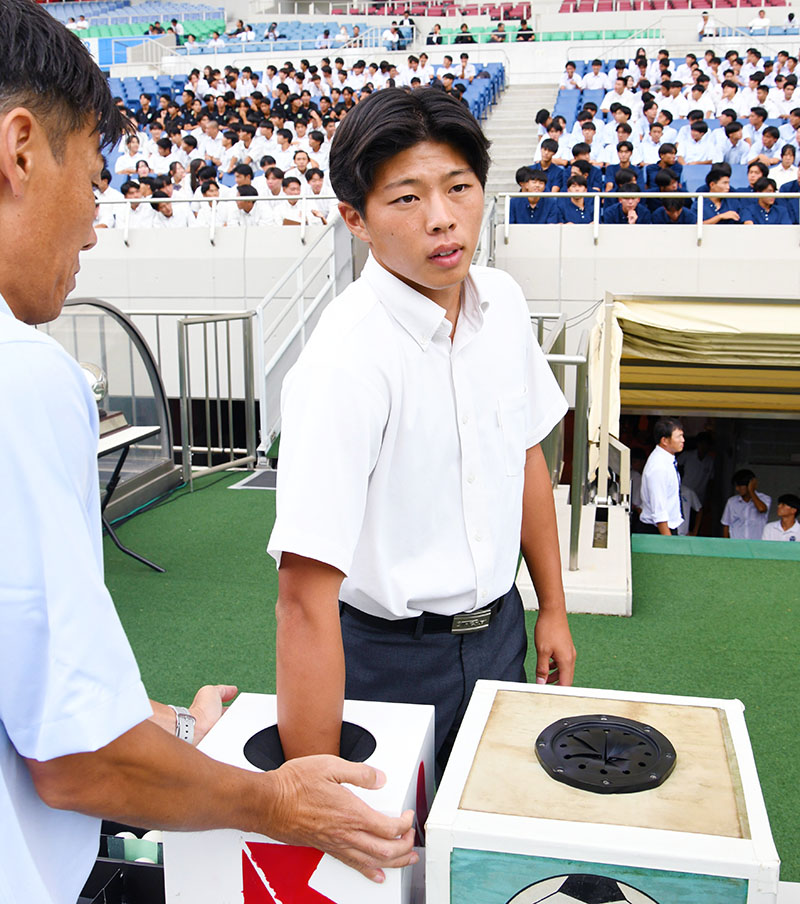 真剣な表情でくじを引く各校の主将たち＝22日午後、埼玉スタジアム