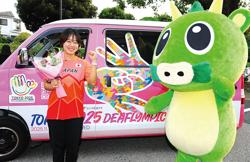 東京2025デフリンピックのPRカーの前でガッツポーズする陸上女子の門脇翠選手