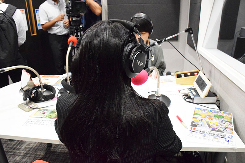 ラジオ番組で情報提供を呼びかけ、犯人に向けて手紙を読む小関孝徳さんの母親（手前）＝30日午前、熊谷市筑波のFMクマガヤ