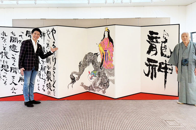 自身の人生哲学を画と書で表現した作品の前に立つ郷ひろみさん（左）と制作した金田石城さん