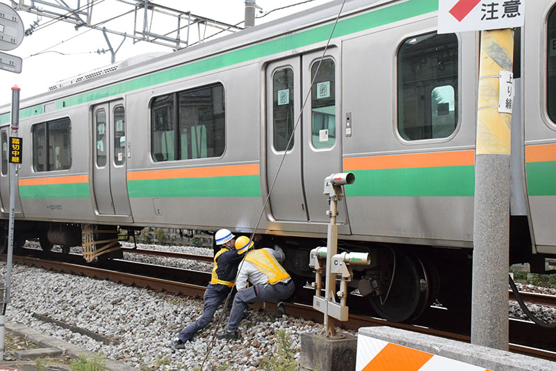 列車と乗用車の衝突事故で、列車の復旧作業を進める作業員ら＝21日午前、鴻巣市箕田