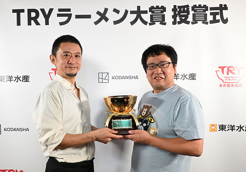 県内店舗では初の「TRYラーメン大賞」に輝いた、かねかつ店主の大友勝さん（左）と審査員の田中一明さん（(C)講談社ビーシー／講談社）