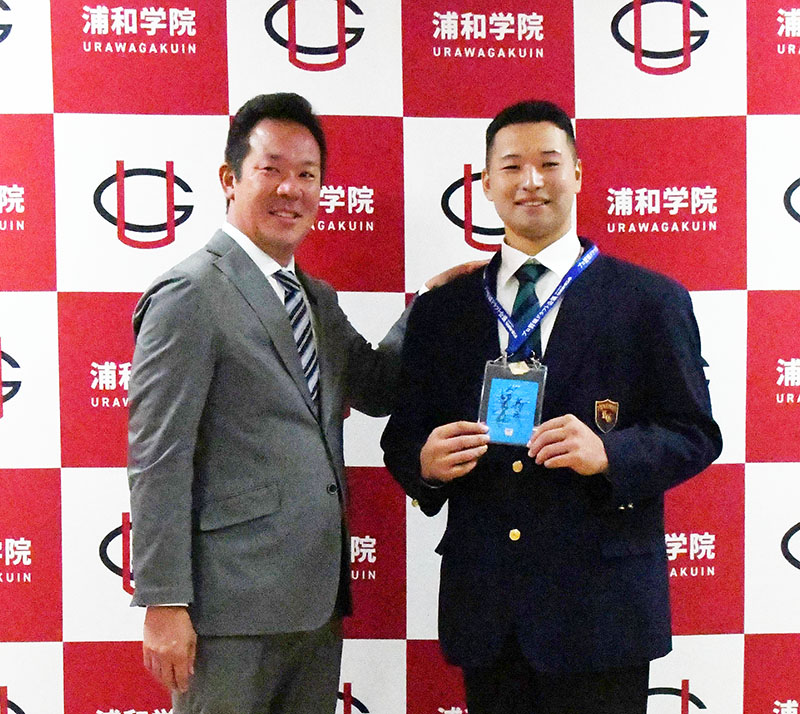 巨人の大場スカウト（左）からドラフト6位指名のあいさつを受ける浦和学院の藤井健翔内野手＝29日、さいたま市緑区