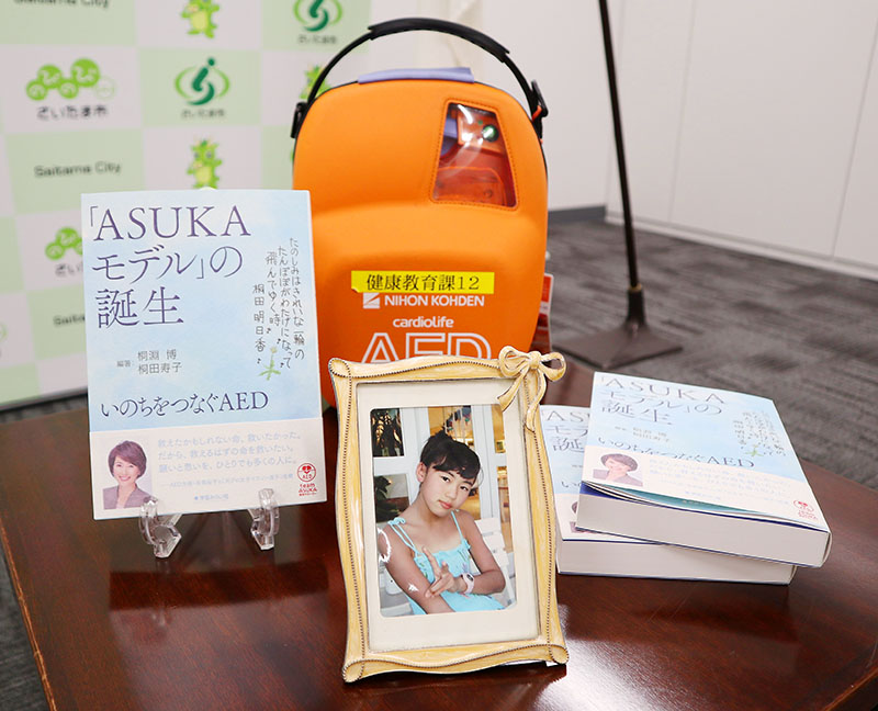 9月30日に刊行した本「『ASUKAモデル』の誕生　いのちをつなぐAED」と明日香さんの写真
