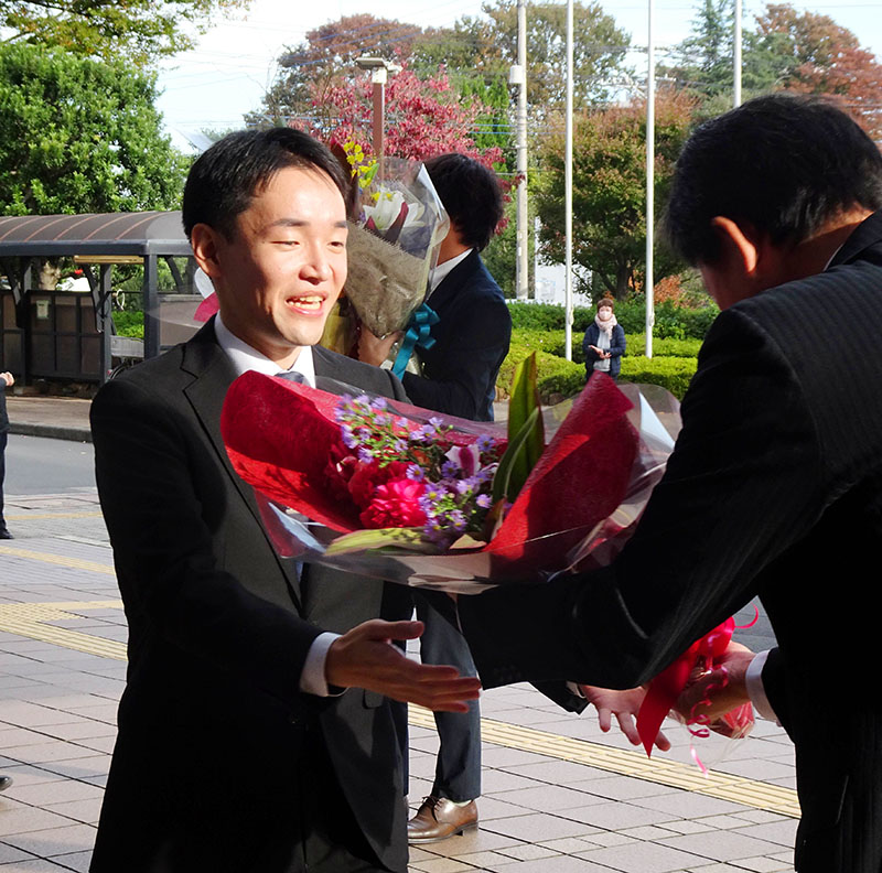 市役所に初登庁し花束を受け取る小川尋海市長＝5日午前8時10分すぎ、鶴ケ島市三ツ木