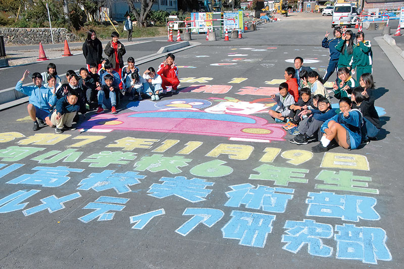 完成した絵を囲み記念撮影をする大河小学校の児童と小川高校の生徒ら