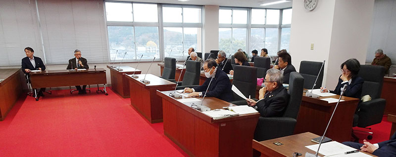 三松保則さん（左から2人目）の話を聴く町議ら＝2日午前、越生町役場議場