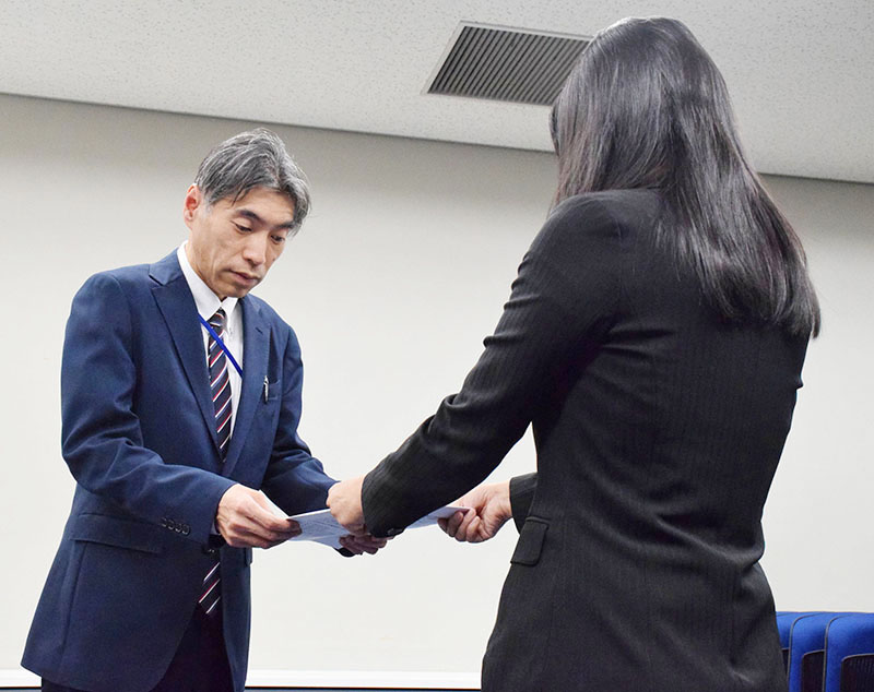 嘆願書と署名を松島隆仁参事官（左）に手渡す小関孝徳さんの母親代里子さん＝9日午後、東京都千代田区の法務省