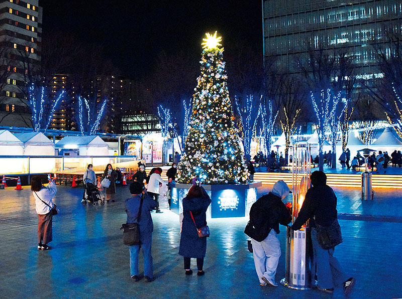けやきひろばに設置されたクリスマスツリーを撮影する来場者