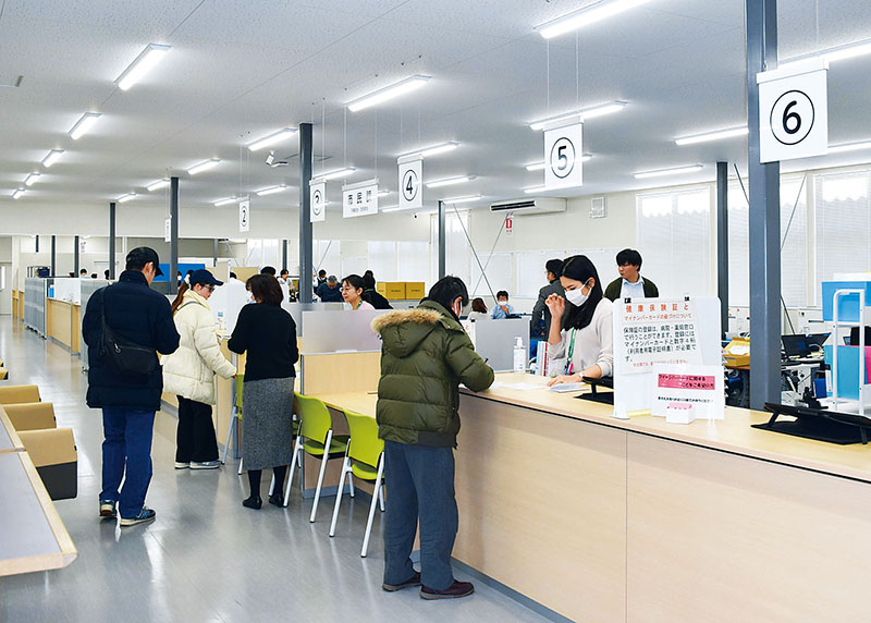 白岡市の仮設庁舎で窓口業務を行う職員ら＝15日午前