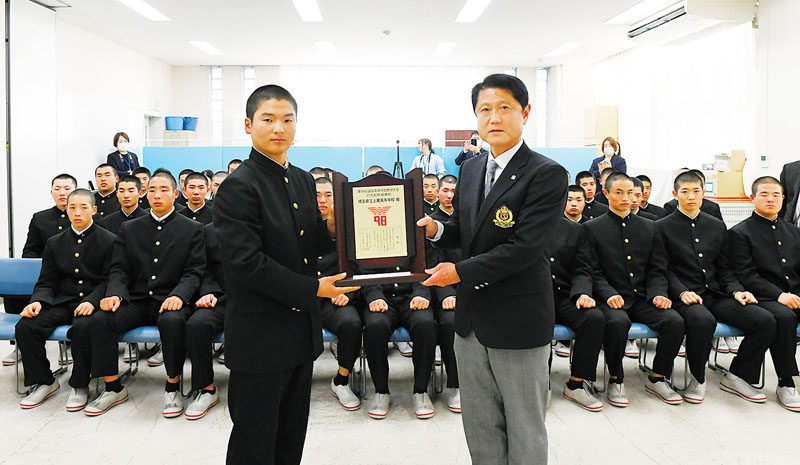 部員の前で記念盾を掲げる森田佑樹主将（左）と県高校野球連盟の斎藤明博会長
