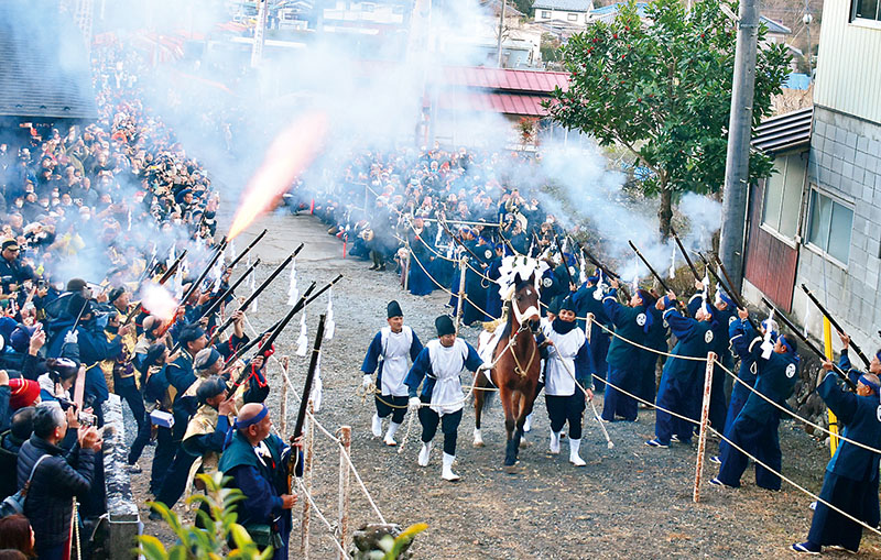 火縄銃の硝煙の中を駆ける御神馬＝14日午後4時ごろ、小鹿野町飯田の八幡神社