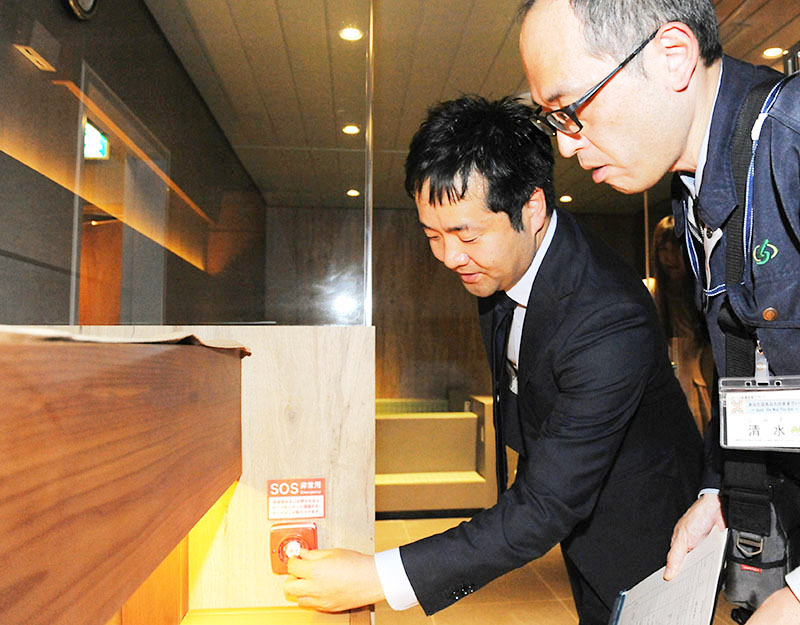 サウナ室で非常ボタンが正常に作動するかを確認するさいたま市の担当者（右）と施設の運営責任者＝26日午後、さいたま市大宮区桜木町の「WAW大宮」