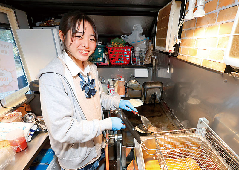 キッチンカーの中で調理する八木さん