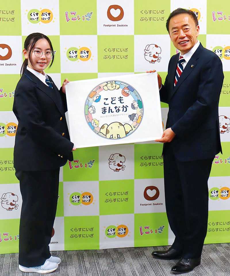 並木傑市長とステッカーを持つ県立新座総合技術高校デザイン科1年の藤掛奏海さん（左）