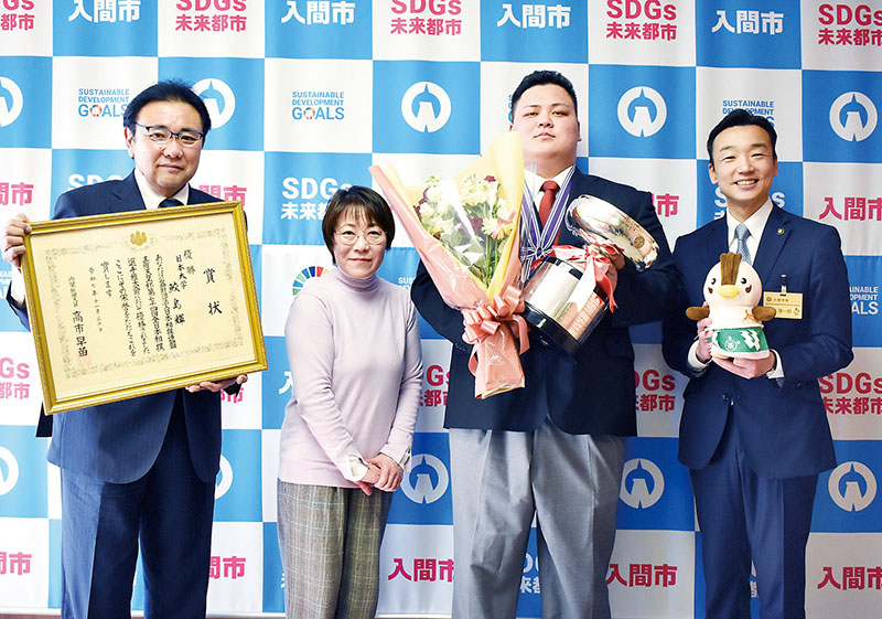 （右から）杉島理一郎市長、鮫島輝さん、鮫島さんの母直美さん、西沢正夫総監督＝6日午後、入間市豊岡の入間市役所
