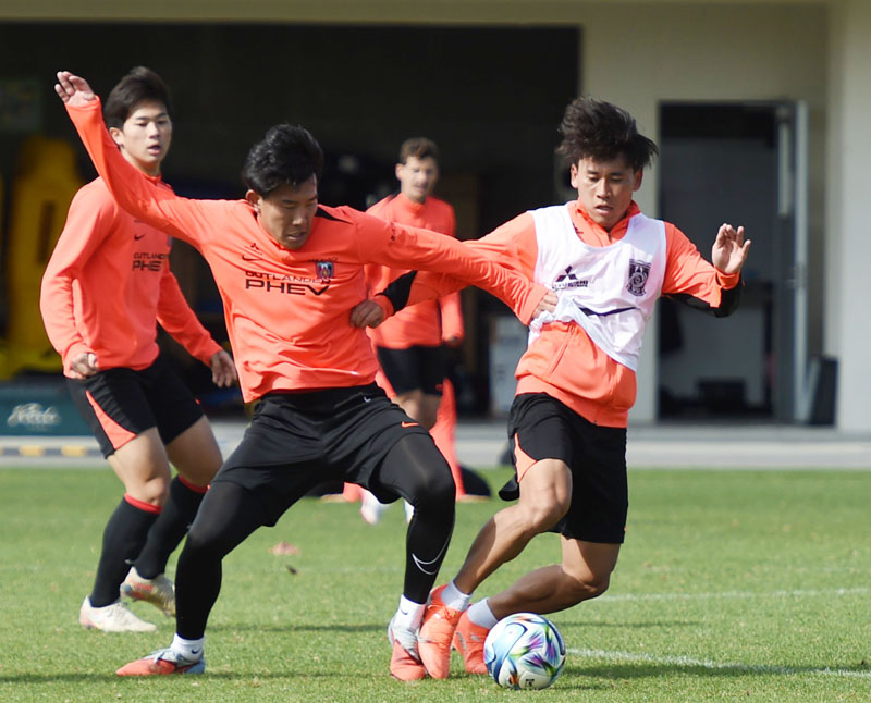 安居（右）と松永がボールを奪い合う＝22日午前、沖縄県の金武町フットボールセンター