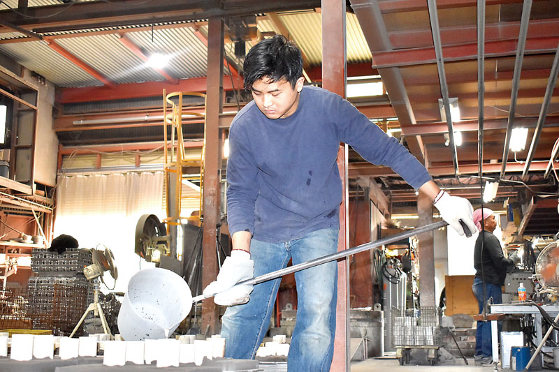 鋳型に熱したアルミを注ぐユリ・サプトロさん＝19日、川口市