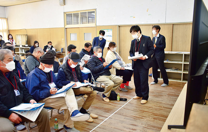 従来の地上波放送と衛星中継放送の違いを見比べる小鹿野町の住民＝17日午後、小鹿野町藤倉地区の集会場