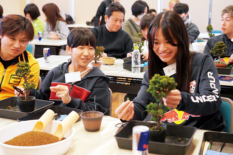 参加者の児童と一緒に盆栽を制作する選手たち（(C)2024 RB OMIYA Inc.）