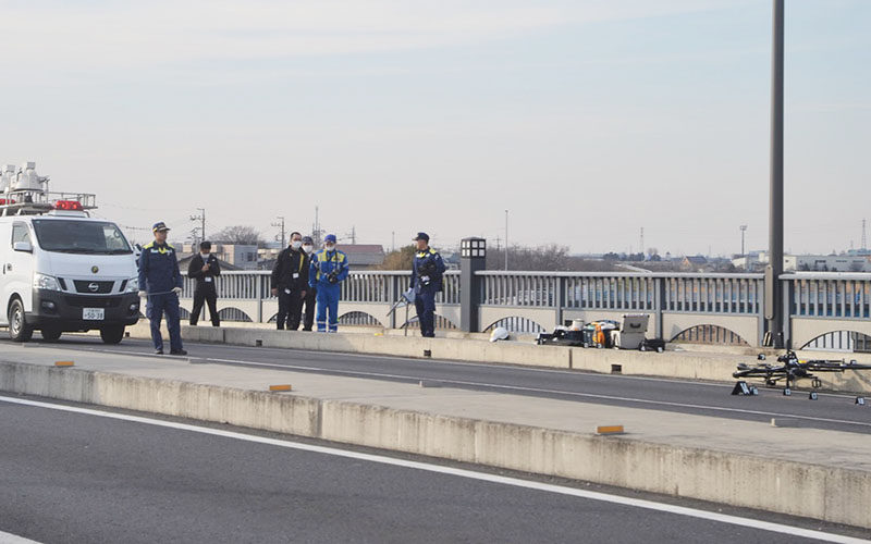 事故現場を調べる警察官＝5日午後3時半ごろ、越谷市と吉川市に架かる吉川橋の橋上