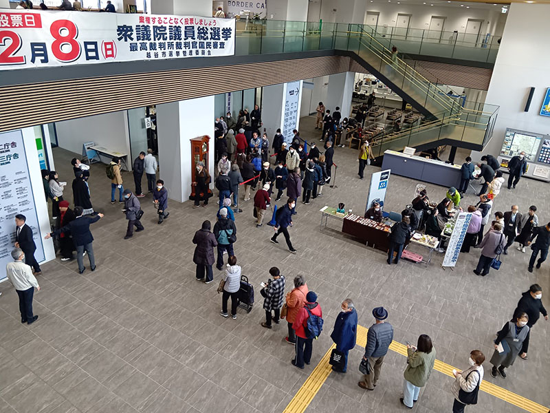 期日前投票所の受付前で長い列をつくる有権者