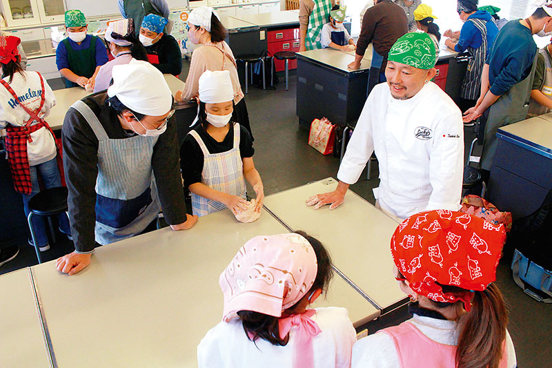 ヘルスケアブレッドラッキーズの臼井大吉さん（右）のアドバイスを受けながらパン作りを楽しむ参加者ら