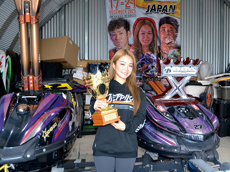 所有する水上バイクを背に年間世界女王の優勝カップを手にする金子真珠選手＝行田市内