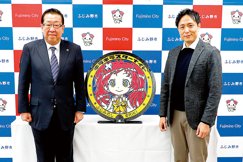 設置式典に参加したゲームソフト製作者で漫画家の「RIKI」さん（右）と高畑博市長＝ふじみ野市役所（同市提供）
