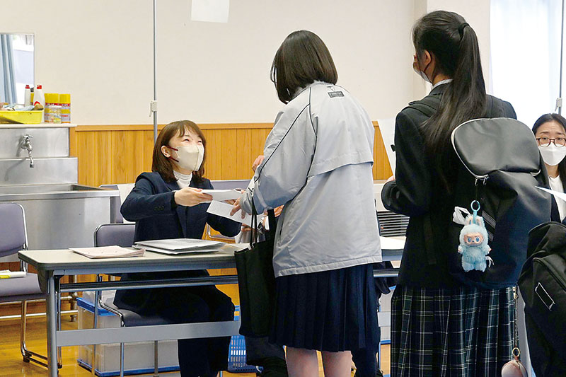高校入学に関する資料を受け取る合格者＝6日午前、川越市六軒町の県立川越女子高校